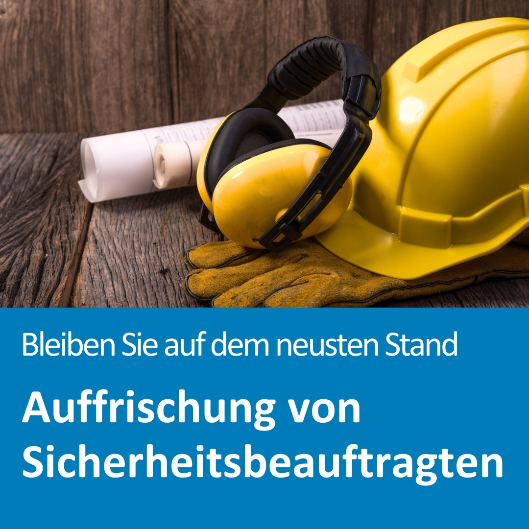 Auf einem rustikalen Holztisch liegen ein gelber Schutzhelm, gelbe Gehörschützer und ein Paar Arbeitshandschuhe nebeneinander. Dahinter sind zusammengerollte technische Bauzeichnungen zu sehen. Der Text auf dem Bild lautet: „Bleiben Sie auf dem neusten Stand – Auffrischung von Sicherheitsbeauftragten“.