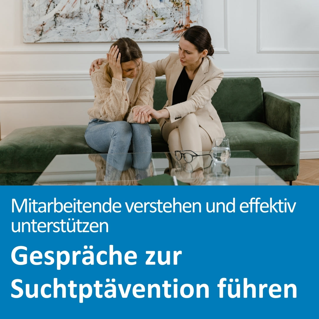 Zwei Frauen sitzen auf einem grünen Sofa in einem Beratungssetting. Eine Frau wirkt emotional belastet und hält sich den Kopf, während die andere sie tröstend berührt und ihr aufmerksam zuhört. Auf dem Glastisch vor ihnen stehen zwei Gläser Wasser und eine Brille. Die Szene vermittelt Unterstützung und Empathie. Im unteren Bereich des Bildes steht der Text: „Mitarbeitende verstehen und effektiv unterstützen – Gespräche zur Suchtprävention führen“.
