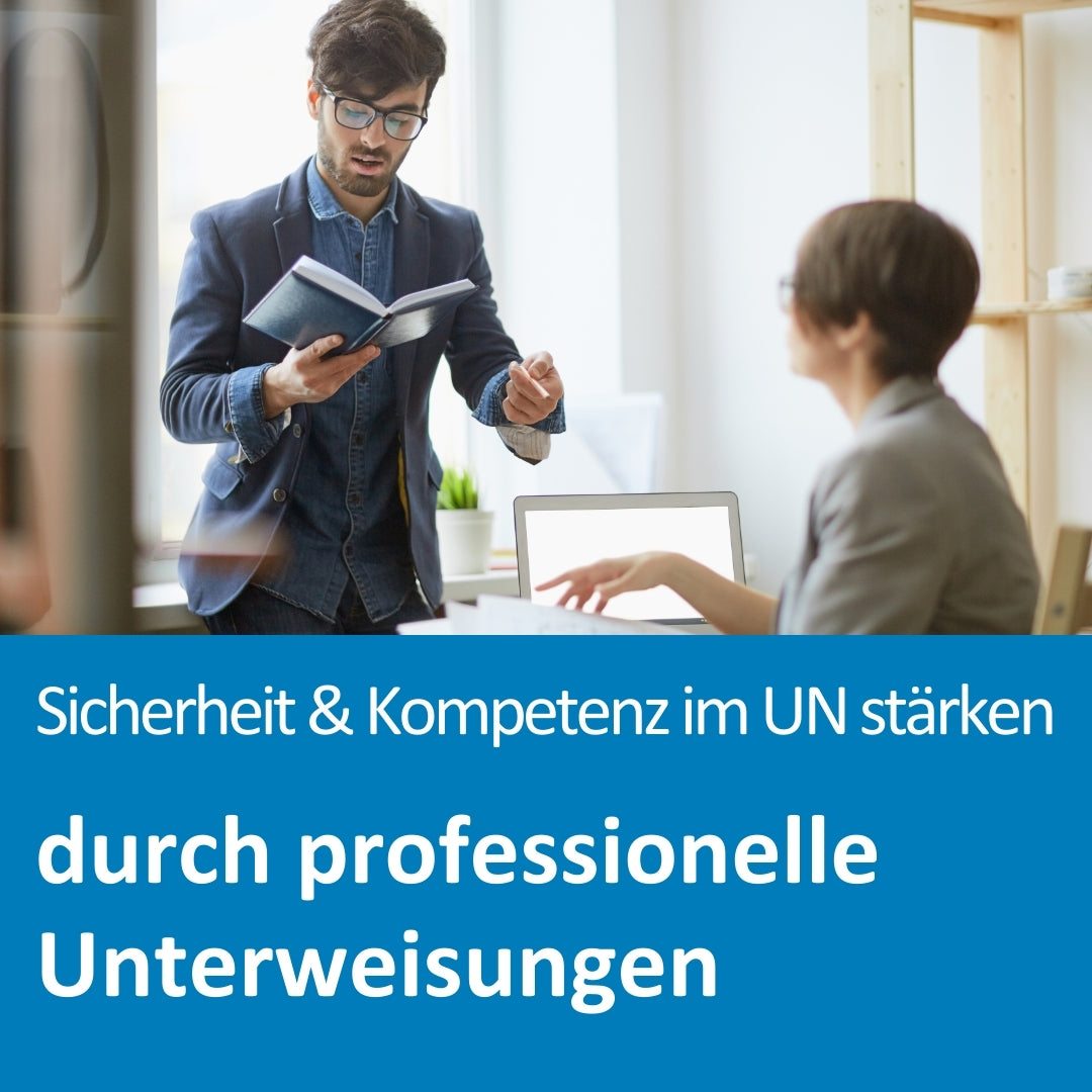 Ein junger Mann mit Brille steht in einem modernen Büro, hält ein geöffnetes Notizbuch in der Hand und spricht gestikulierend zu einer sitzenden Kollegin, die auf einen Laptop zeigt. Die Szene vermittelt eine Schulung oder Unterweisungssituation. Der eingeblendete Text auf dem Bild lautet: „Sicherheit & Kompetenz im Unternehmen stärken durch professionelle Unterweisungen“.